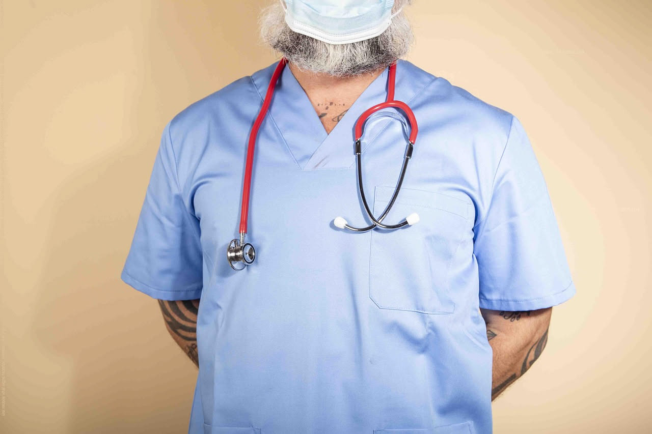 Un medico in camice bianco esamina un grafico con linea rossa in salita su uno schermo, accanto a documenti con esami di laboratorio e risultati di PSA nel corso degli anni