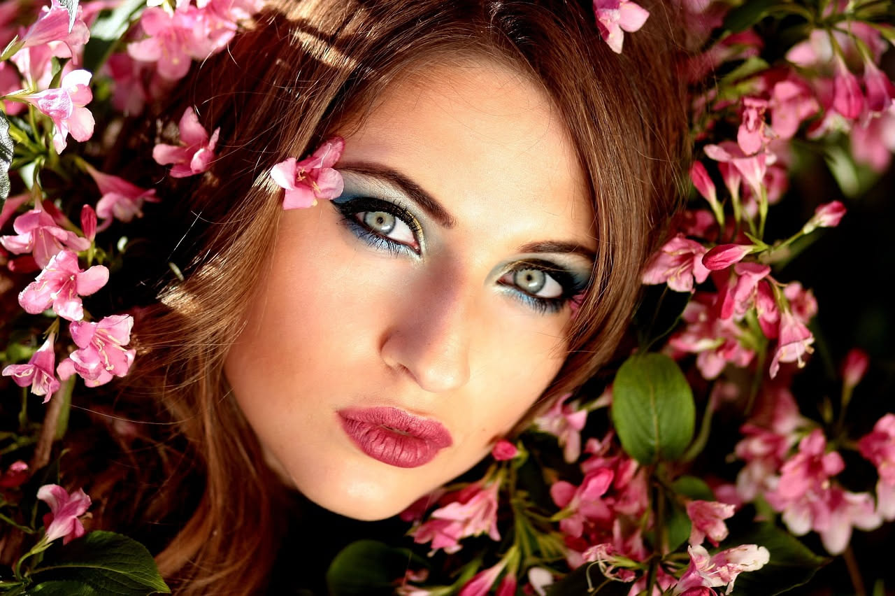 Viso di donna al mattino con luce naturale primaverile, pelle leggermente lucida, primo piano occhi e guance, finestra con luce bianca diffusa sullo sfondo