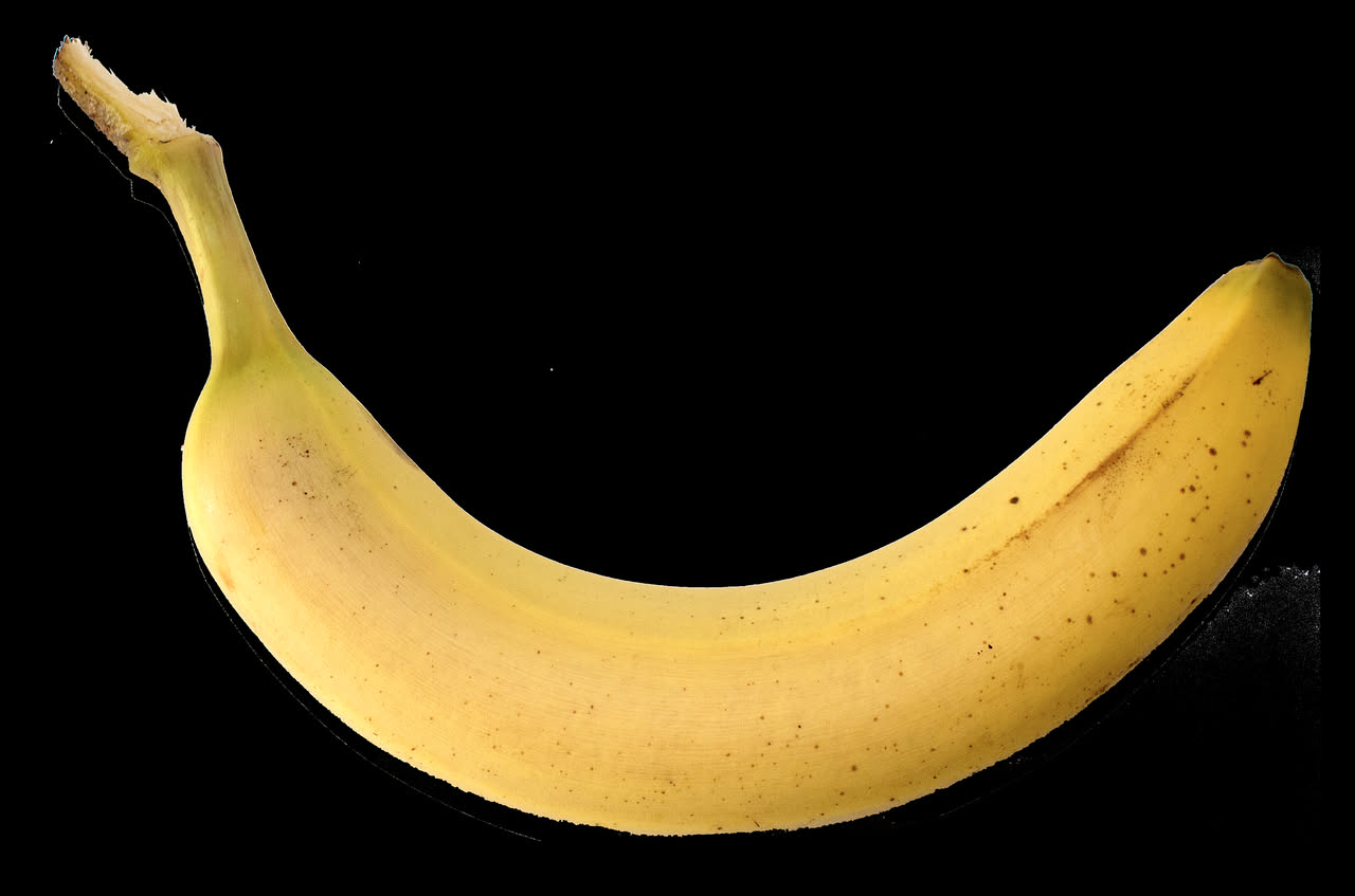 Banana matura aperta a metà su un asciugamano da palestra accanto a una bottiglia d'acqua e a un paio di scarpe da corsa, in ambiente sportivo.